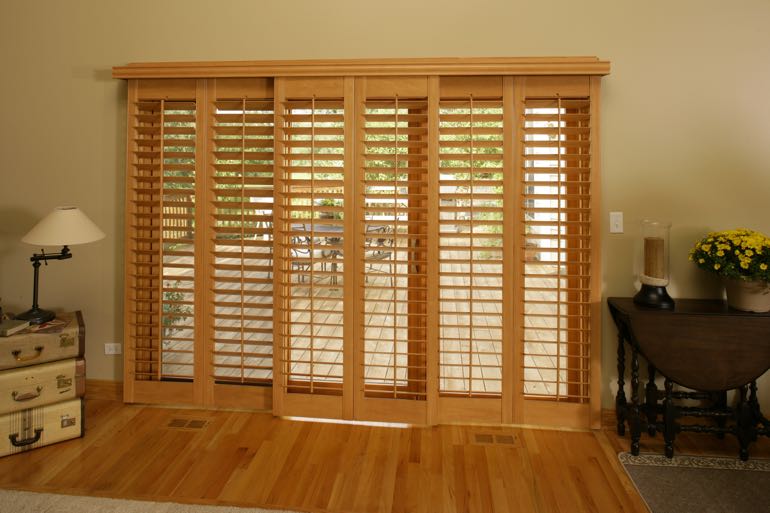 plantation shutters on sliding door leading to back porch.